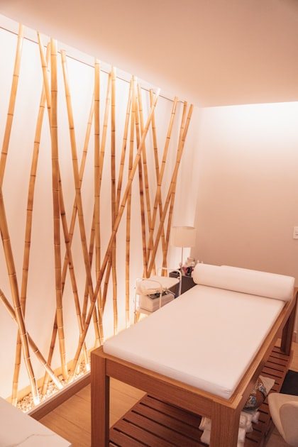 A quiet Desert Zen treatment room with a white-draped table and natural bamboo wall